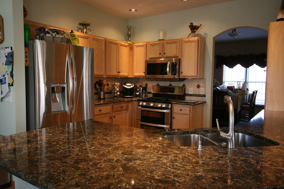 Open concept kitchen - mid-sized transitional l-shaped ceramic tile open concept kitchen idea with an undermount sink, recessed-panel cabinets, light wood cabinets, quartz countertops, beige backsplash, ceramic backsplash, stainless steel appliances, green walls and a peninsula
