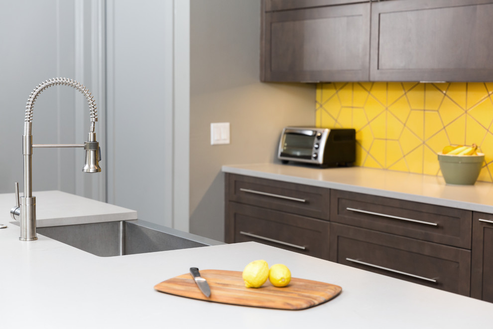 This is an example of a large contemporary single-wall eat-in kitchen in Dallas with an undermount sink, flat-panel cabinets, dark wood cabinets, quartz benchtops, yellow splashback, ceramic splashback, stainless steel appliances and with island.