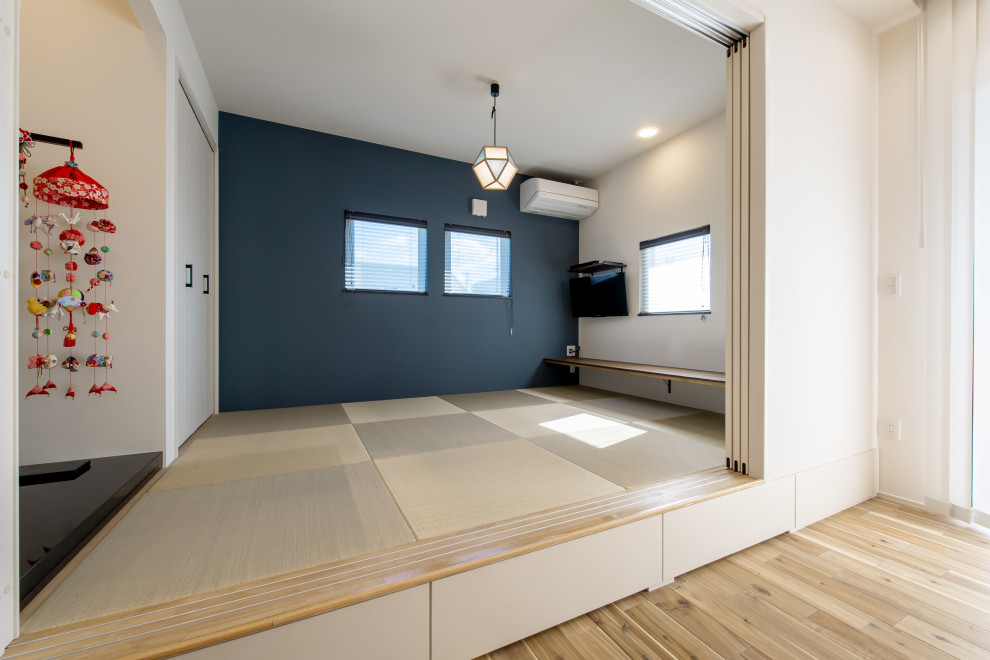 Photo of a mid-sized open concept living room in Other with tatami floors, wallpaper and wallpaper.