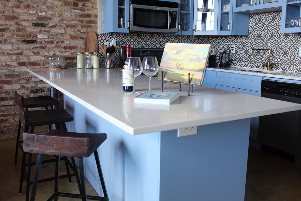 Mid-sized transitional u-shaped concrete floor and beige floor eat-in kitchen photo in Atlanta with an undermount sink, glass-front cabinets, blue cabinets, quartzite countertops, multicolored backsplash, ceramic backsplash, stainless steel appliances, a peninsula and white countertops