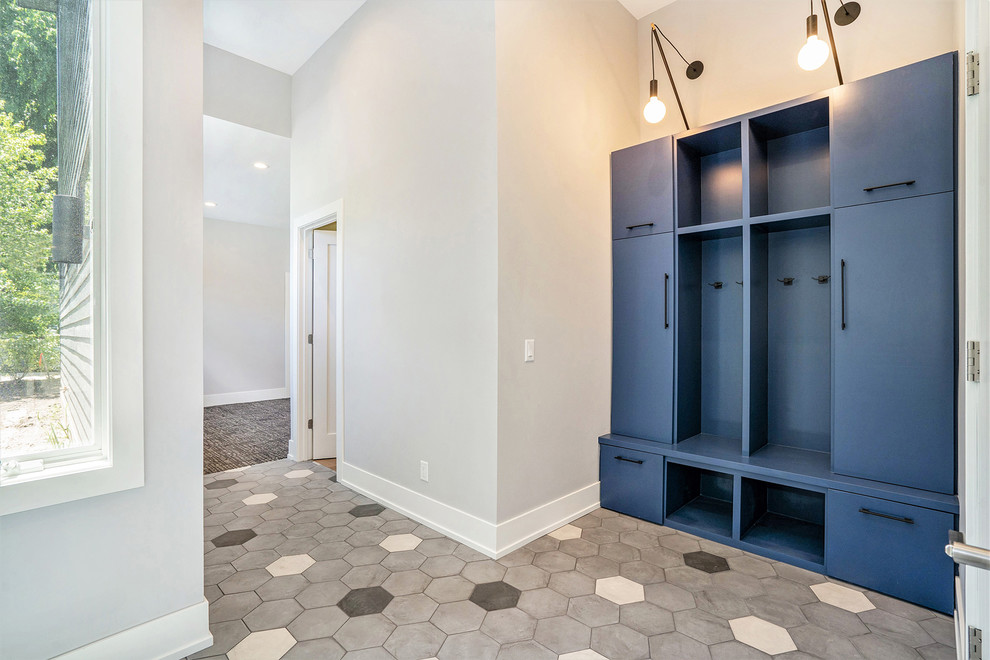 Small transitional ceramic tile and multicolored floor mudroom photo in Grand Rapids with flat-panel cabinets, blue cabinets and gray walls