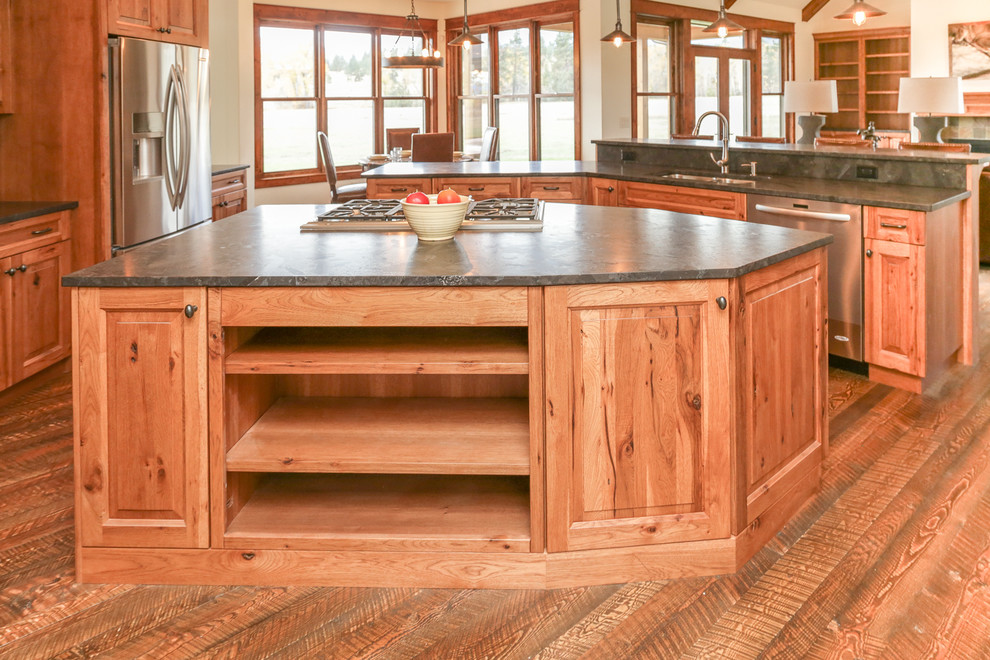Mid-sized mountain style l-shaped dark wood floor and brown floor open concept kitchen photo with an undermount sink, raised-panel cabinets, medium tone wood cabinets, two islands and gray countertops
