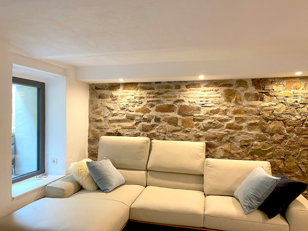 Modernes Wohnzimmer mit gewölbter Decke und Steinwänden in Essen