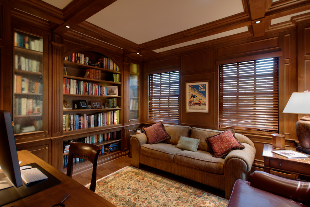 Large traditional study room in Chicago with medium hardwood floors, a built-in desk, brown walls, brown floor and coffered.
