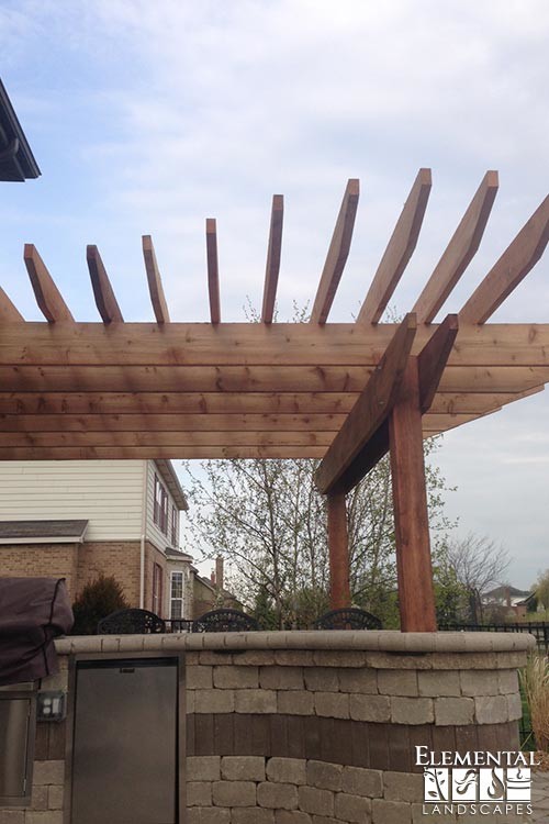 Inspiration for a mid-sized transitional backyard concrete paver patio kitchen remodel in Chicago with a pergola