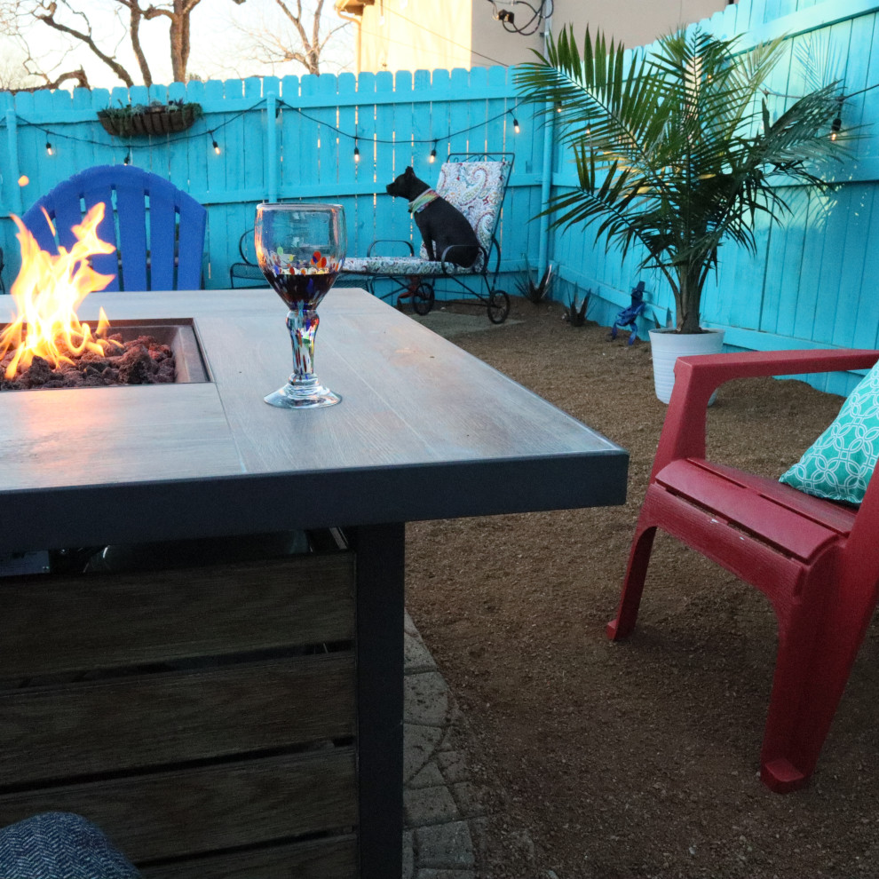 Example of a small eclectic backyard decomposed granite patio design in Austin with a fire pit