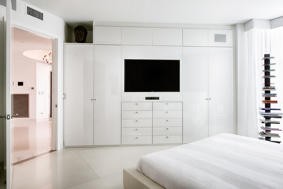 Photo of a mid-sized contemporary master bedroom in Miami with white walls and concrete floors.