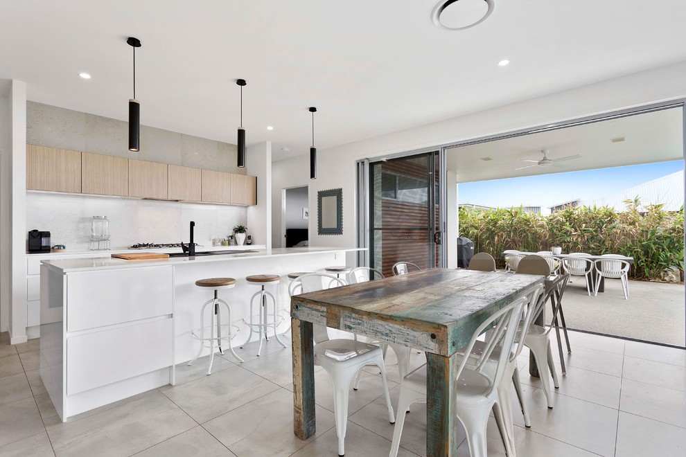 Inspiration for a mid-sized contemporary galley open plan kitchen in Brisbane with flat-panel cabinets, quartz benchtops, grey splashback, ceramic splashback, stainless steel appliances, with island, an integrated sink, light wood cabinets and grey floor.