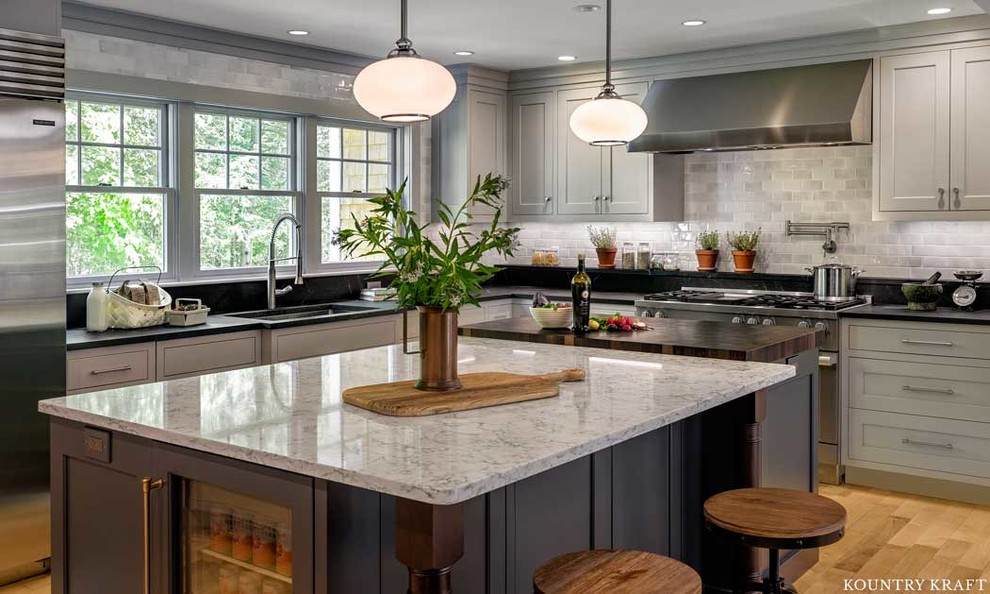 Transitional u-shaped eat-in kitchen in Boston with an undermount sink, beaded inset cabinets, grey cabinets, marble benchtops, grey splashback, subway tile splashback, stainless steel appliances, light hardwood floors, with island, beige floor and grey benchtop.