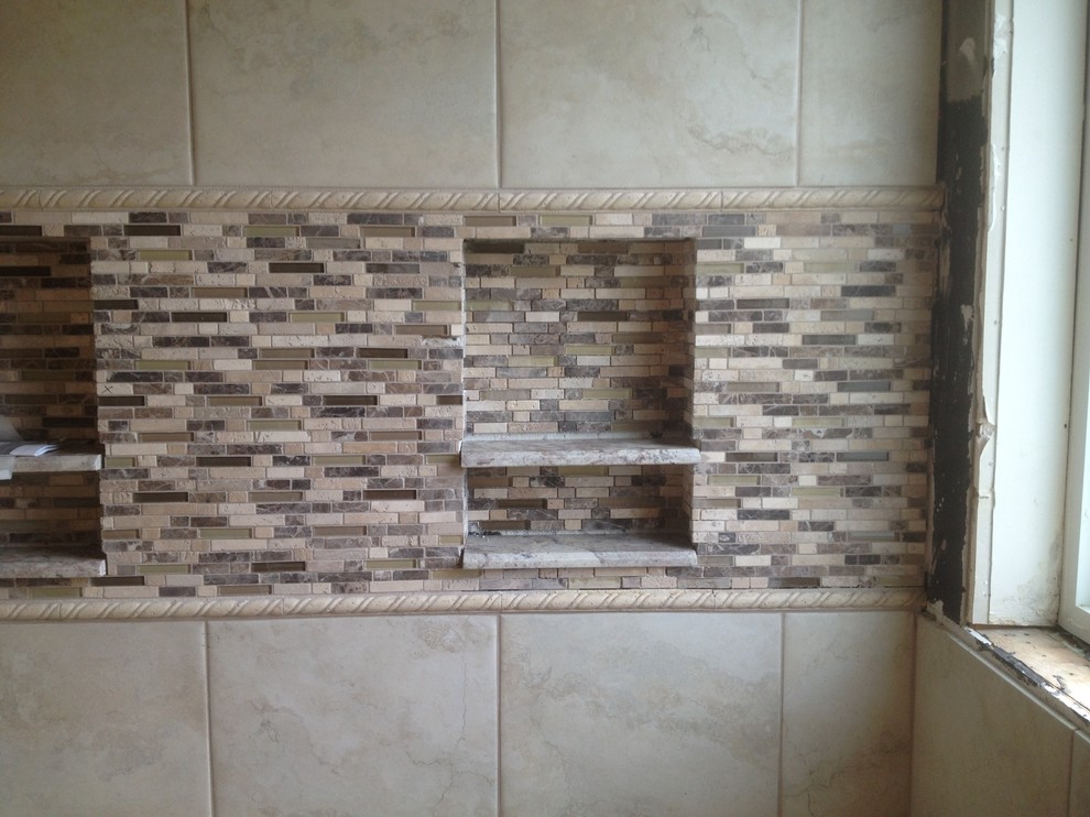 Example of a large transitional master beige tile, brown tile and stone slab corner shower design in Houston with raised-panel cabinets, white cabinets, a two-piece toilet, beige walls, an undermount sink and granite countertops