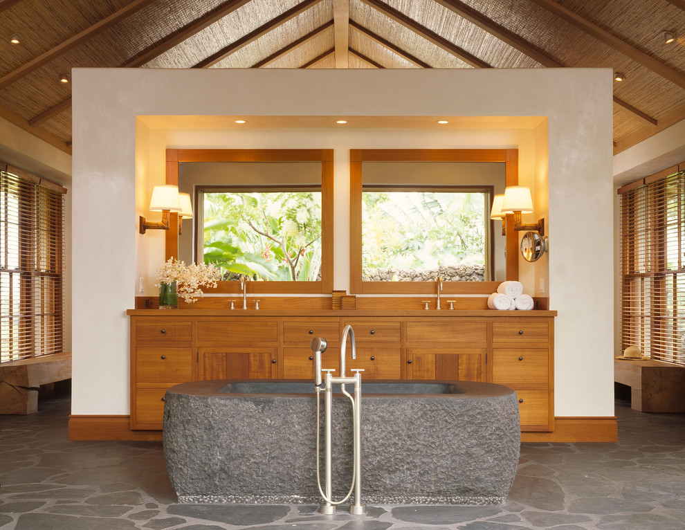 Inspiration for a tropical bathroom in San Francisco with medium wood cabinets and a freestanding tub.