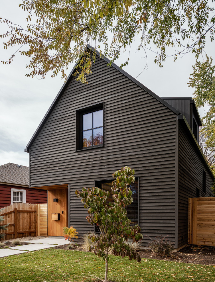 Imagen de fachada de casa negra y negra moderna pequeña de tres plantas con revestimiento de madera, tejado a dos aguas y tablilla