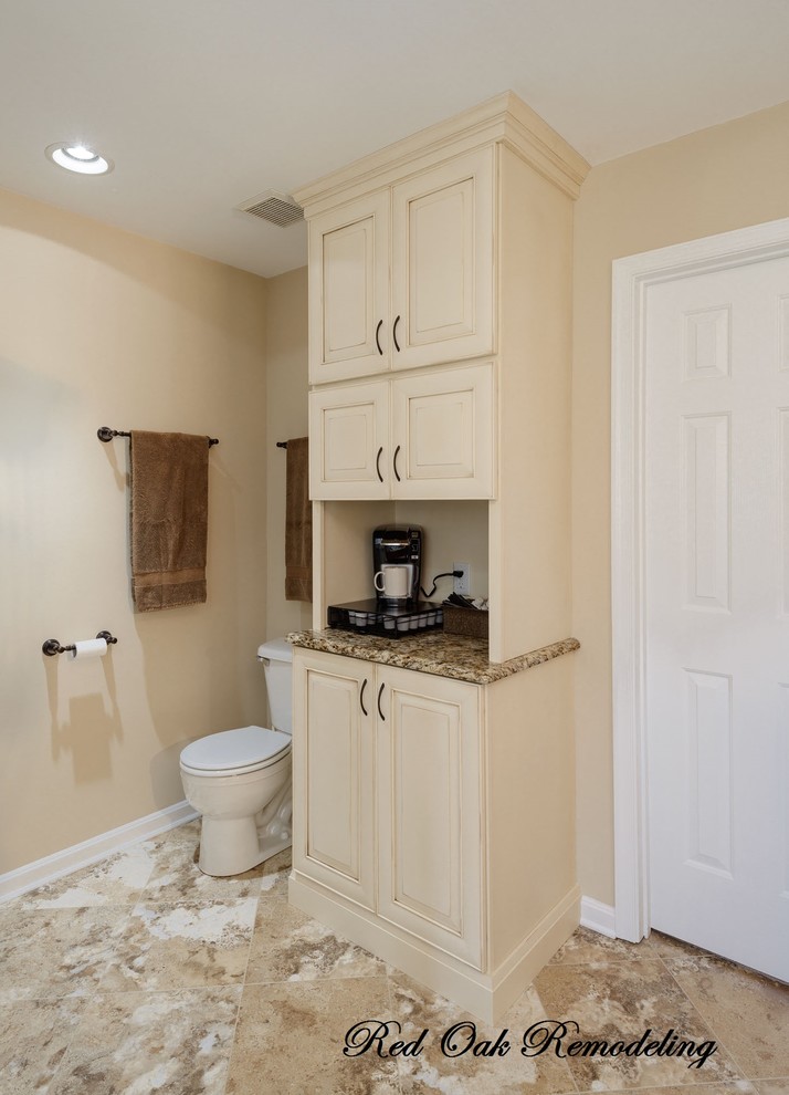 Inspiration for a large traditional master bathroom in Other with beige cabinets, granite benchtops, a corner shower, beige walls, a two-piece toilet, beige tile, multi-coloured tile, stone tile and travertine floors.