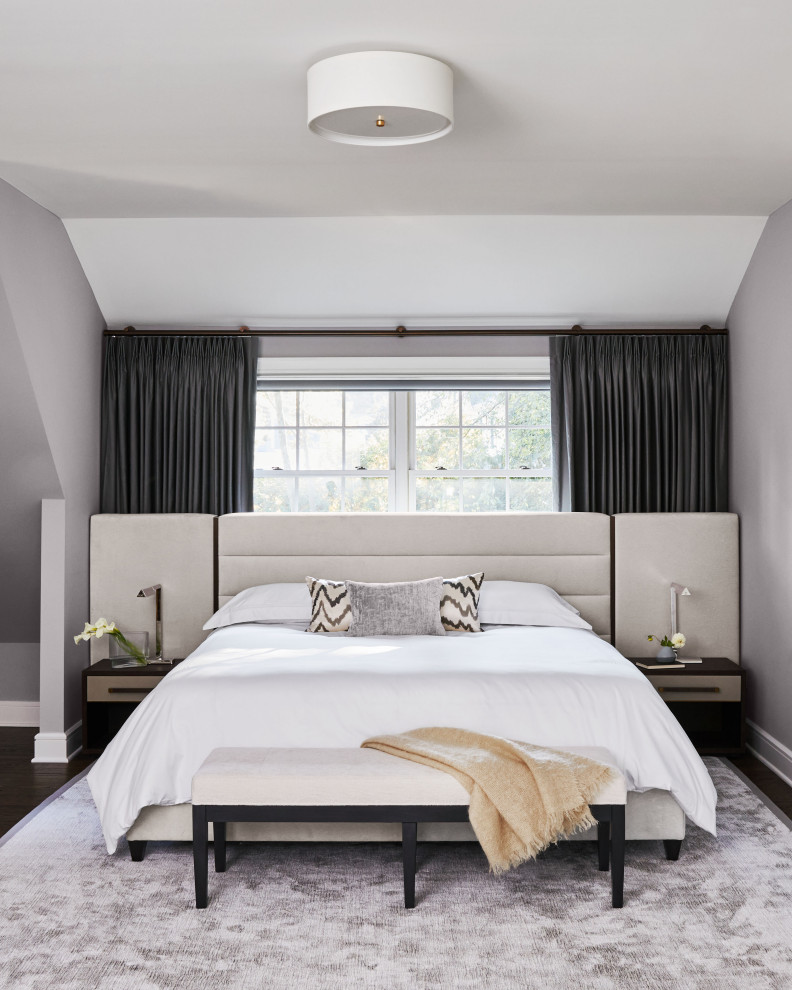 Medium sized traditional master and grey and black bedroom in New York with white walls, medium hardwood flooring, no fireplace and brown floors.