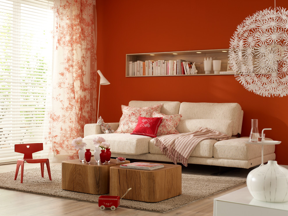 Photo of a contemporary family room in Hamburg with red walls and light hardwood floors.