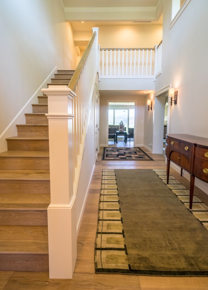 Photo of a large traditional entry hall in Orange County with white walls, light hardwood floors, a double front door and a white front door.