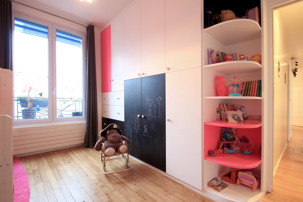 Cette image montre chambre d'enfant for fille With un mur blanc and parquet clair.
