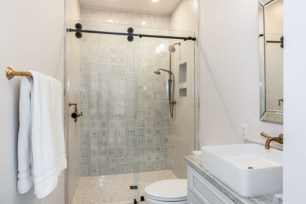 Exempel på ett mellanstort maritimt grå grått en-suite badrum, med luckor med upphöjd panel, grå skåp, en öppen dusch, en toalettstol med separat cisternkåpa, grå kakel, marmorkakel, grå väggar, marmorgolv, ett fristående handfat, bänkskiva i kvartsit, grått golv och dusch med gångjärnsdörr