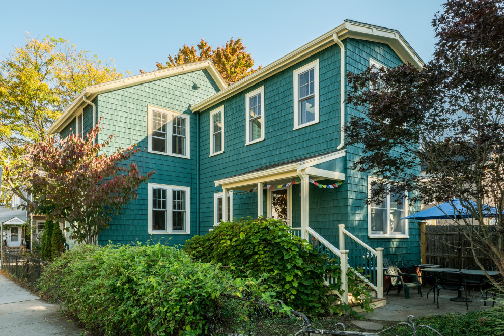 Photo of a mid-sized country two-storey blue house exterior in Boston with wood siding, a gable roof, a shingle roof, a black roof and shingle siding.
