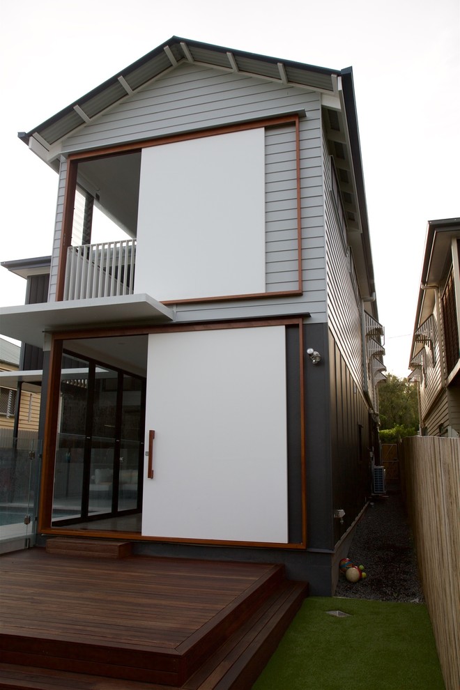 Photo of a mid-sized contemporary two-storey white exterior in Brisbane with wood siding and a gable roof.
