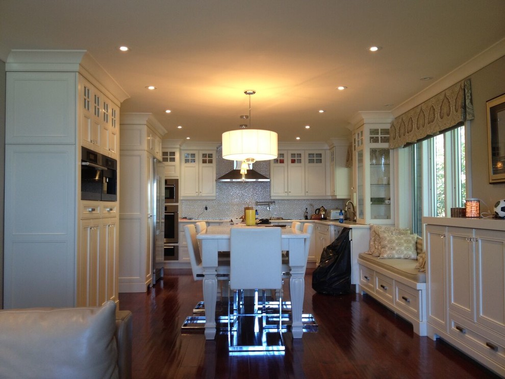 Eat-in kitchen - mid-sized transitional u-shaped medium tone wood floor and brown floor eat-in kitchen idea in Toronto with recessed-panel cabinets, white cabinets, metallic backsplash, mosaic tile backsplash, stainless steel appliances and an island
