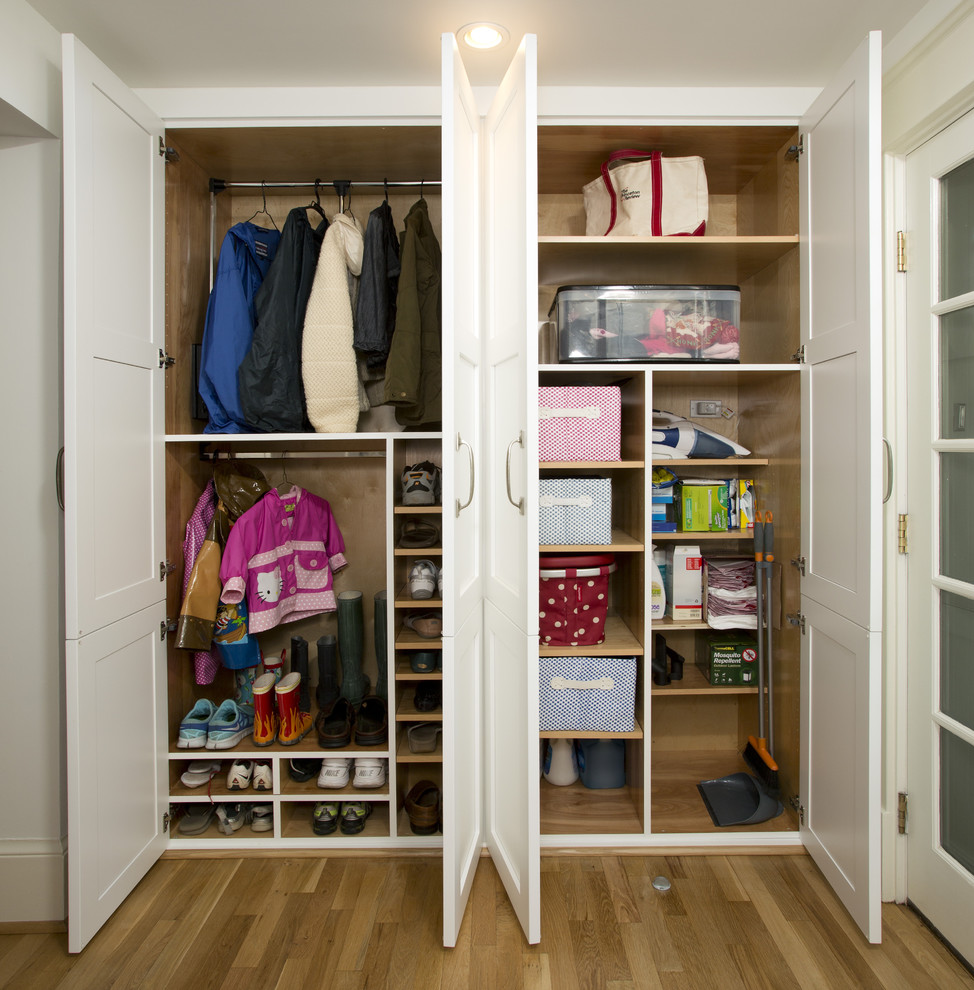 This is an example of a mid-sized transitional mudroom in DC Metro with white walls and light hardwood floors.
