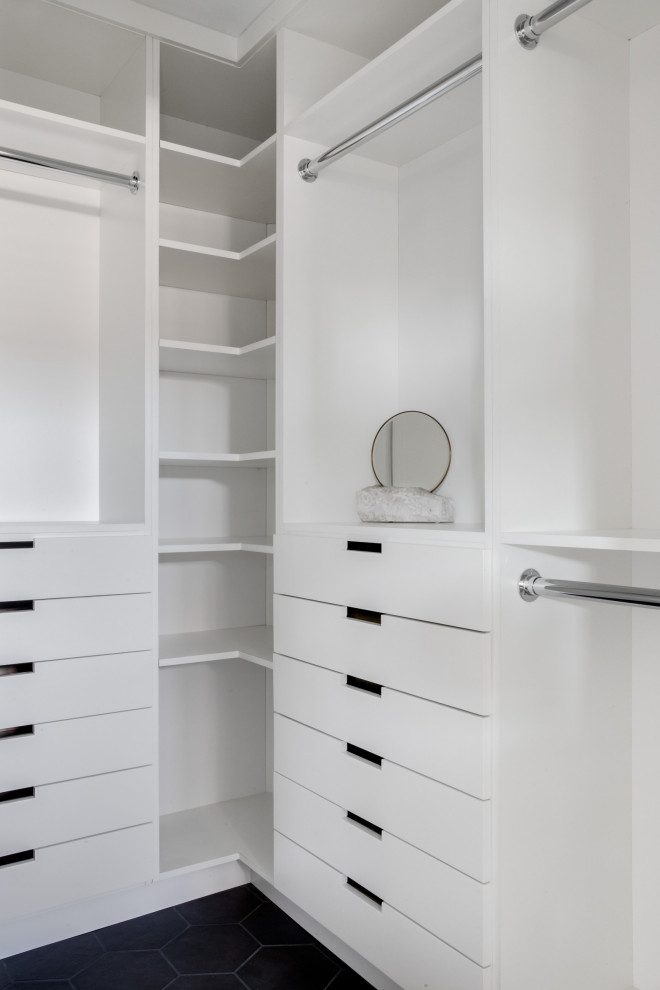 Imagen de armario vestidor actual pequeño con armarios con paneles lisos, puertas de armario blancas, suelo de baldosas de porcelana y suelo negro