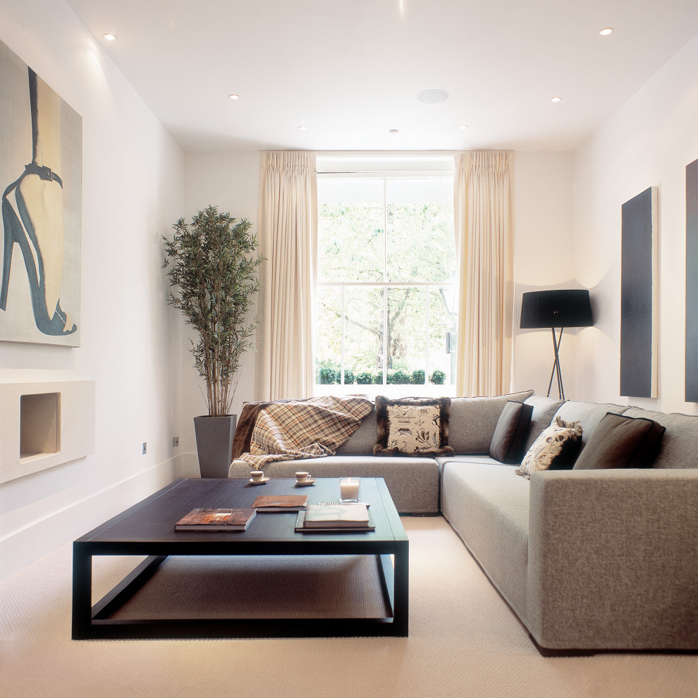 This is an example of a medium sized formal and grey and white open plan living room feature wall in London with beige walls, carpet, a standard fireplace, a stone fireplace surround, a concealed tv, beige floors, a coffered ceiling and a feature wall.