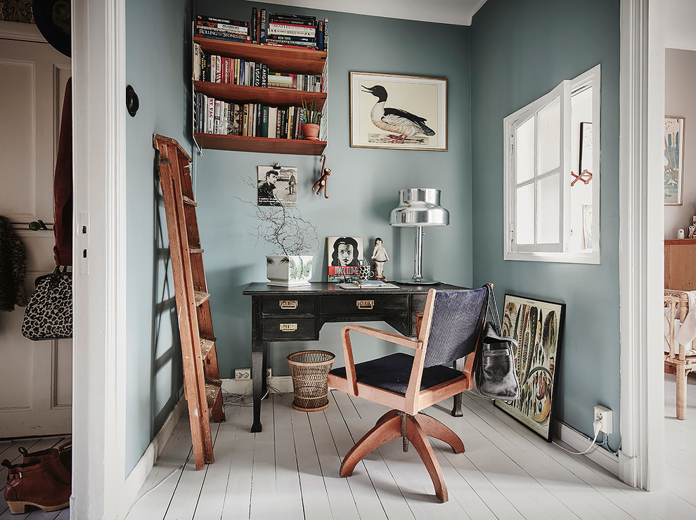 Photo of a mid-sized scandinavian study room in Gothenburg with blue walls, painted wood floors, a freestanding desk and no fireplace.