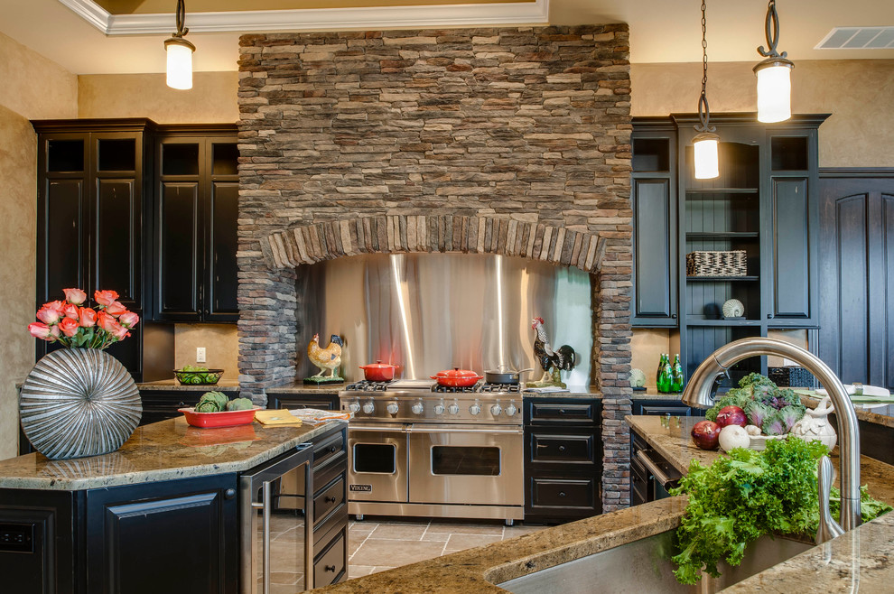 Traditional kitchen in Detroit with stainless steel appliances, metallic splashback, metal splashback, an undermount sink, black cabinets and raised-panel cabinets.