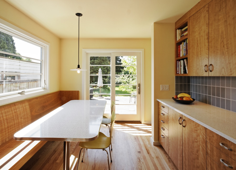 Transitional galley eat-in kitchen in Portland with flat-panel cabinets, medium wood cabinets, blue splashback, recycled glass benchtops, ceramic splashback, a farmhouse sink and stainless steel appliances.