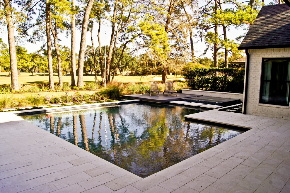 Design ideas for a mid-sized modern backyard custom-shaped natural pool in Houston with a hot tub and natural stone pavers.