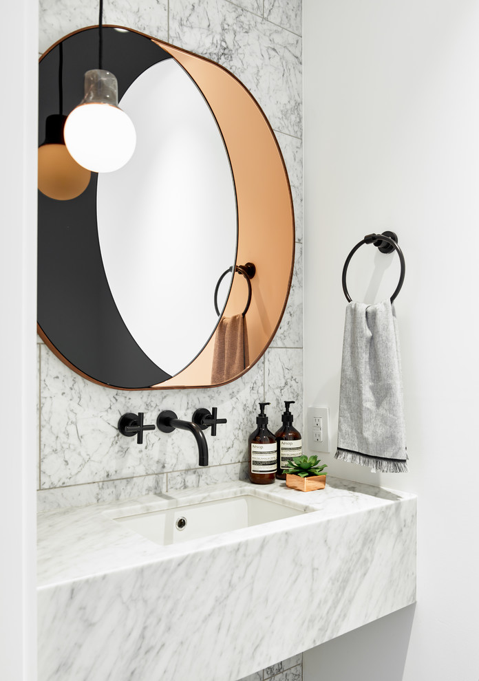 Inspiration for a small contemporary powder room in Toronto with stone tile, white walls, an undermount sink, marble benchtops, white tile and white benchtops.