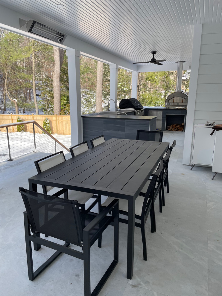 Inspiration for a large modern backyard concrete patio kitchen remodel in New York with a roof extension