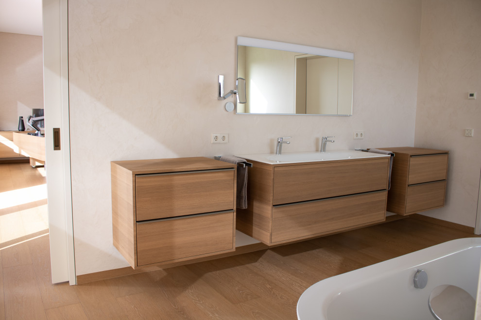 Exempel på ett mycket stort modernt brun brunt en-suite badrum, med släta luckor, bruna skåp, ett fristående badkar, en kantlös dusch, beige väggar, mellanmörkt trägolv, ett nedsänkt handfat, träbänkskiva, brunt golv och med dusch som är öppen