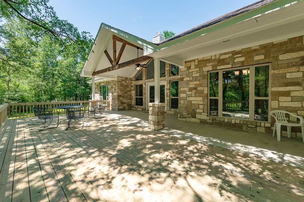 Deck - mid-sized transitional one-story and backyard stone beige deck idea in Austin with a hip roof, a shingle roof and a roof extension