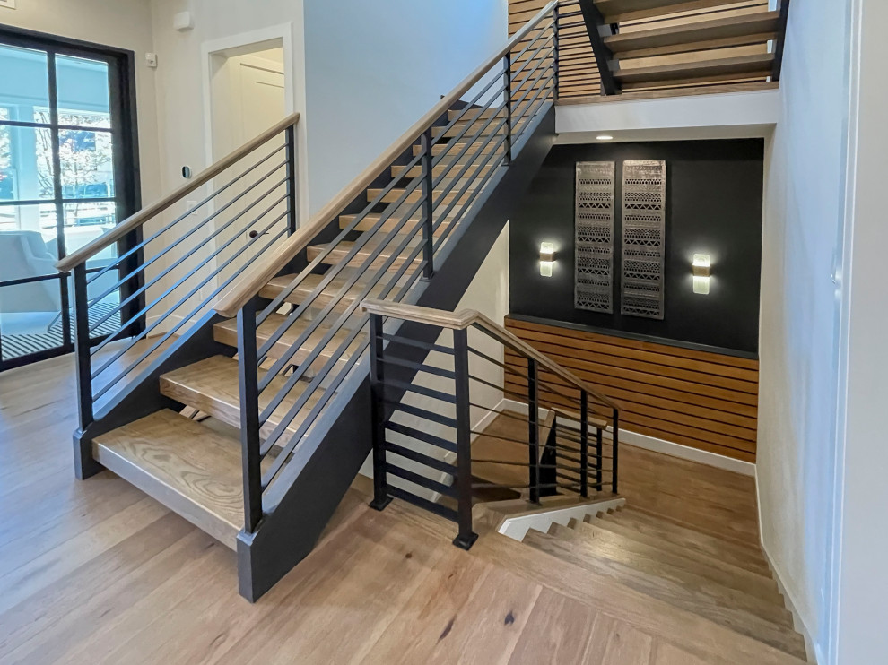 Inspiration for a large contemporary wood straight staircase in DC Metro with mixed railing and panelled walls.