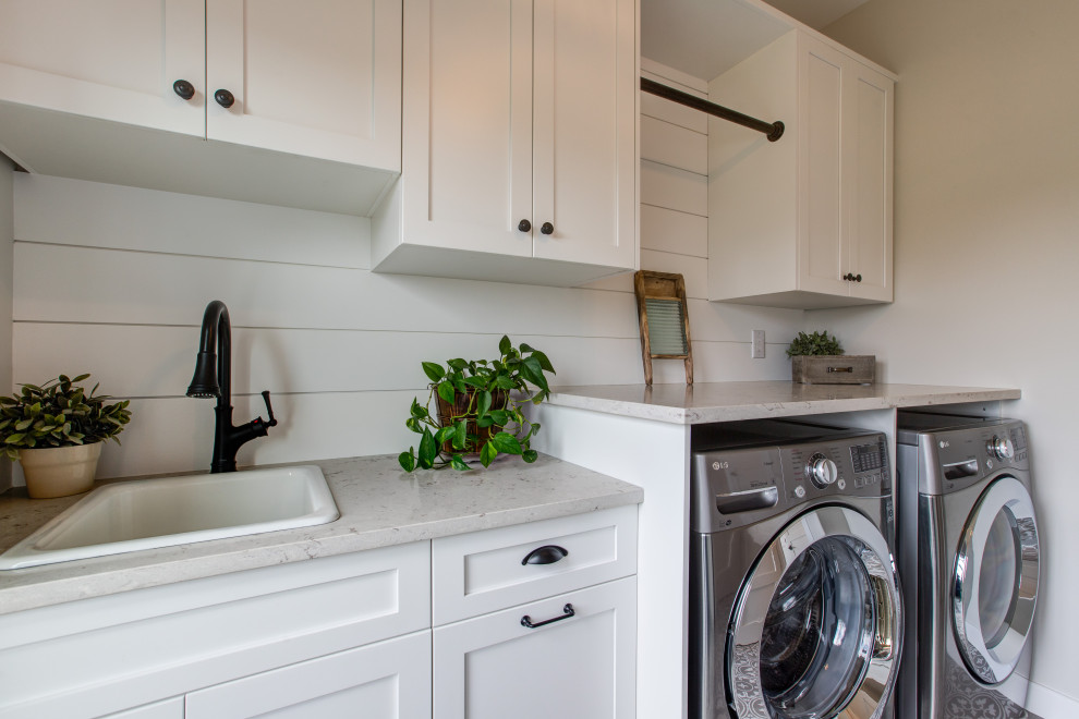 Design ideas for a mid-sized country galley dedicated laundry room in Other with a drop-in sink, shaker cabinets, white cabinets, quartz benchtops, white splashback, timber splashback, beige walls, vinyl floors, a side-by-side washer and dryer, beige floor, beige benchtop and planked wall panelling.