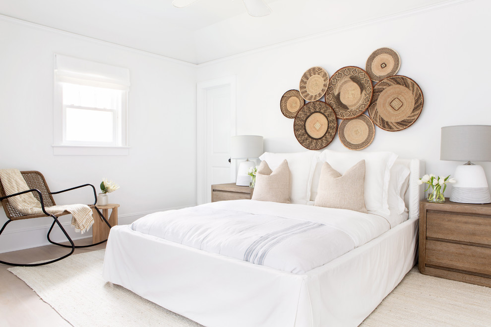 Design ideas for a mid-sized beach style guest bedroom in New York with white walls, light hardwood floors, beige floor and no fireplace.