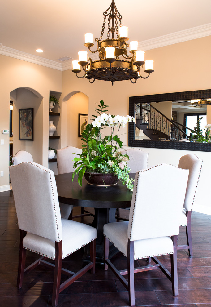 Photo of a large mediterranean dining room in Orange County with dark hardwood floors and beige walls.