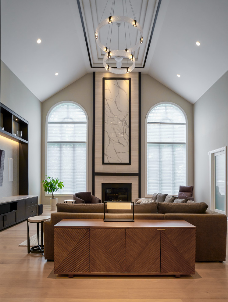 Design ideas for an expansive contemporary enclosed games room in Chicago with beige walls, light hardwood flooring, a standard fireplace, a tiled fireplace surround, a built-in media unit, beige floors and a vaulted ceiling.
