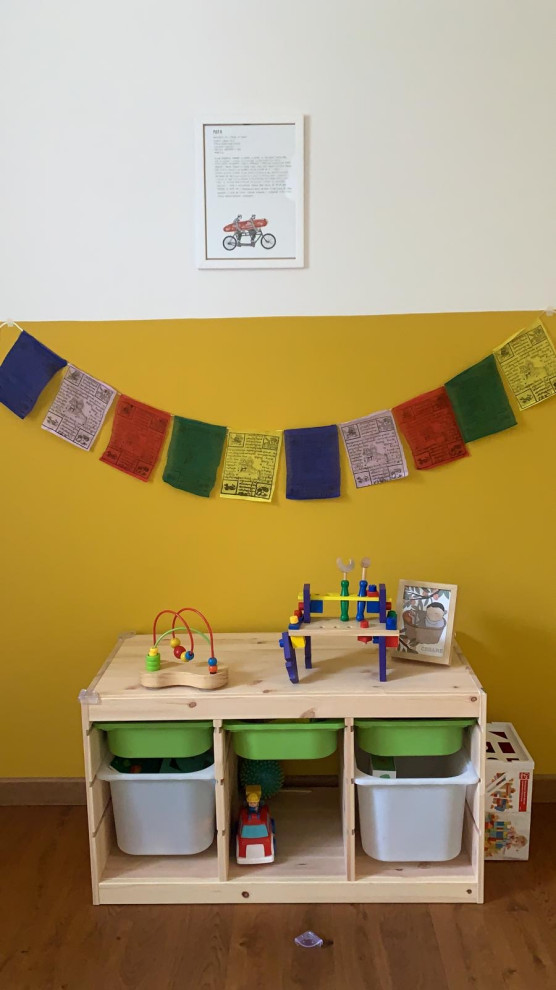 Cette image montre une chambre d'enfant de 1 à 3 ans nordique de taille moyenne avec un mur jaune, parquet clair et un sol marron.