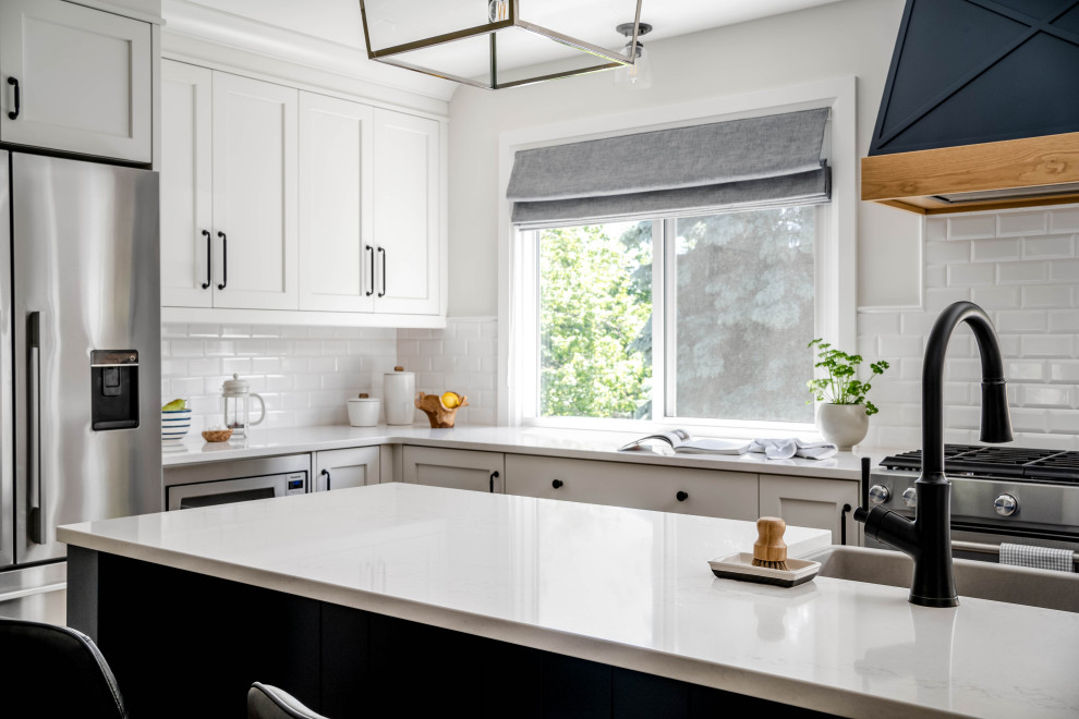 Example of a large transitional l-shaped kitchen design in Toronto with shaker cabinets and an island