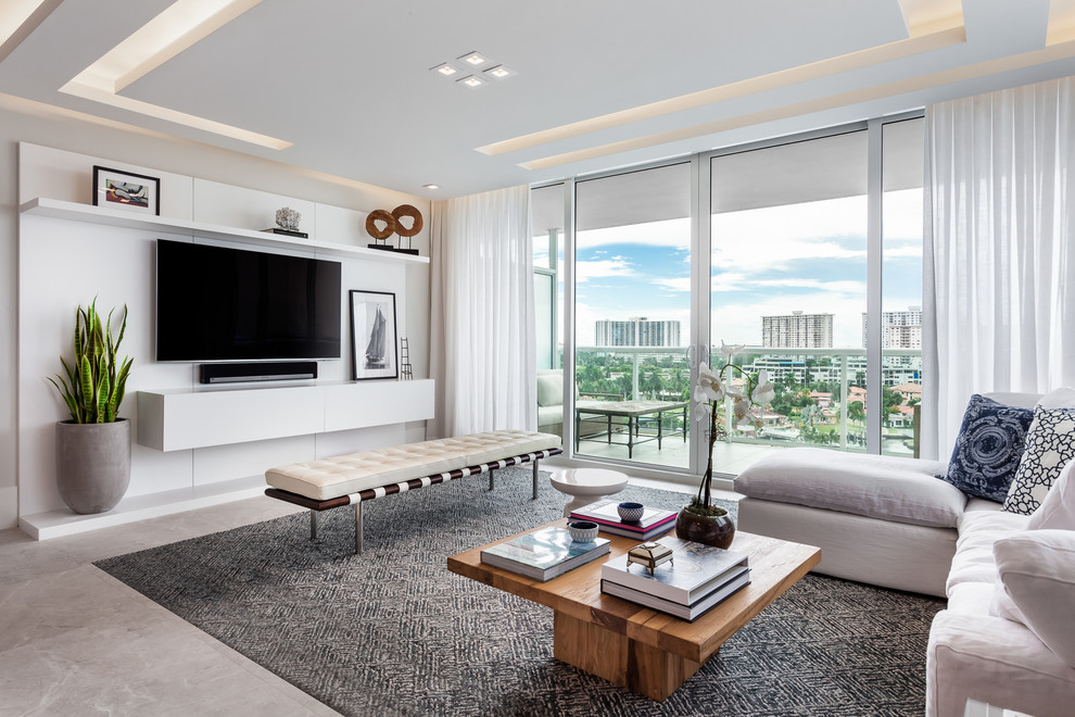 This is an example of a large contemporary enclosed living room in Miami with porcelain floors, a wall-mounted tv, beige floor and grey walls.
