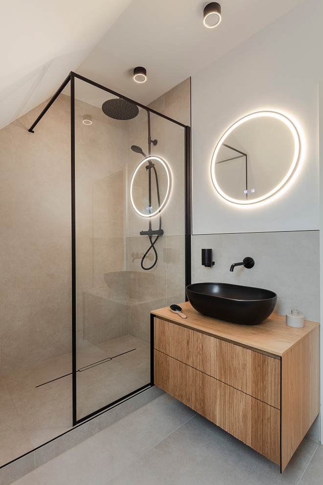 Small modern 3/4 bathroom in Munich with louvered cabinets, medium wood cabinets, a curbless shower, a two-piece toilet, beige tile, stone slab, white walls, a vessel sink, wood benchtops, beige floor, an open shower, brown benchtops, a single vanity and a freestanding vanity.