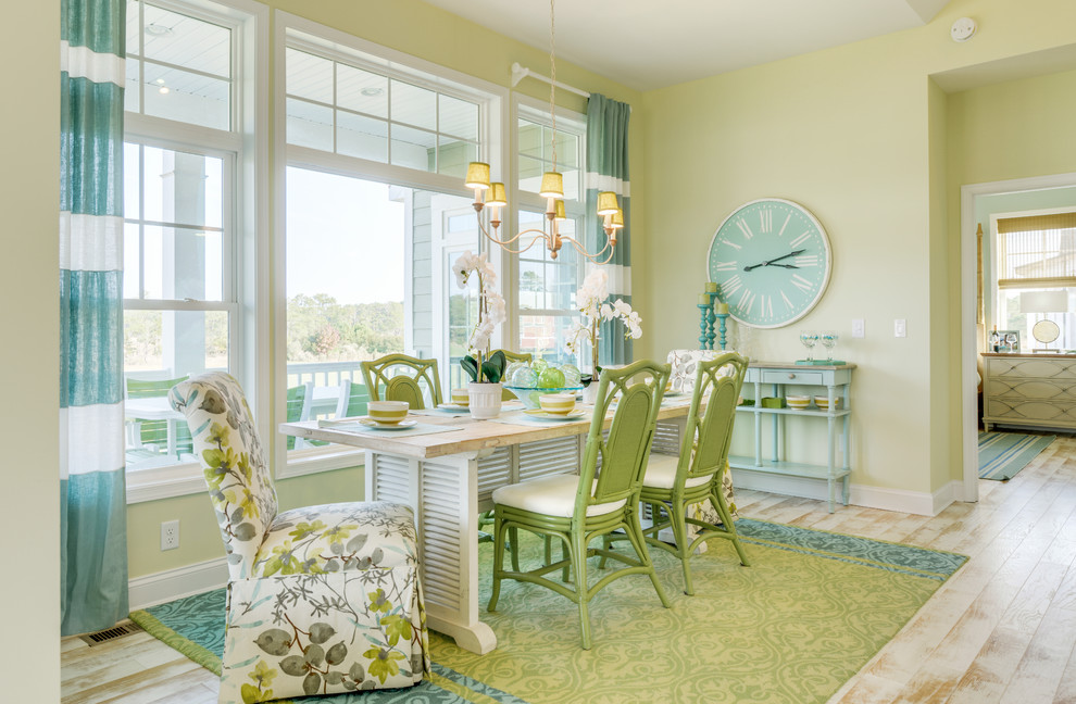 This is an example of a beach style dining room in Other with green walls and beige floor.