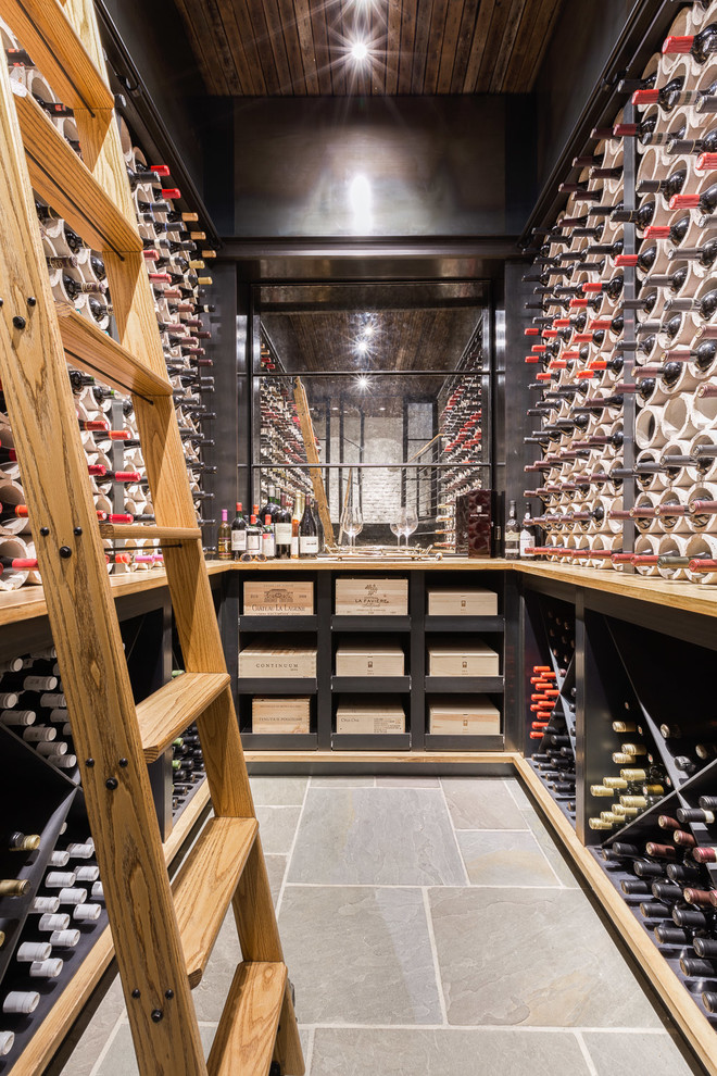 Photo of a mid-sized industrial wine cellar in Other with diamond bins, grey floor and slate floors.