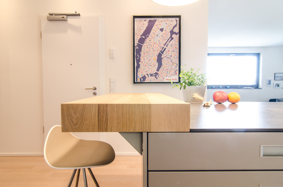 Kleine Moderne Wohnküche ohne Kamin mit weißer Wandfarbe, hellem Holzboden und beigem Boden in Frankfurt am Main