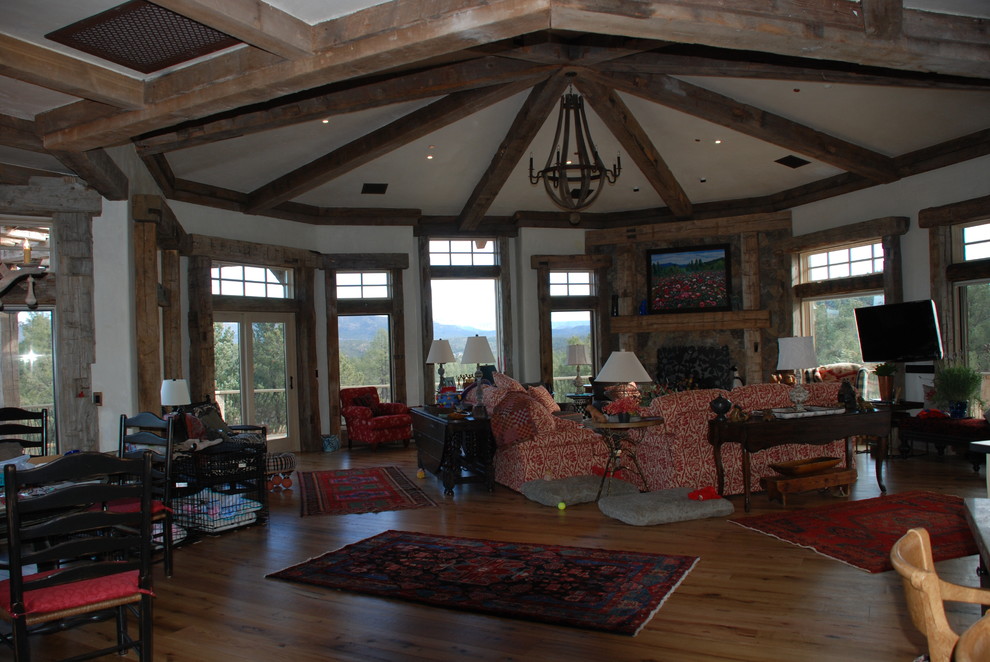 Photo of an expansive country open concept family room in Phoenix with beige walls, medium hardwood floors, a corner fireplace, a stone fireplace surround and no tv.