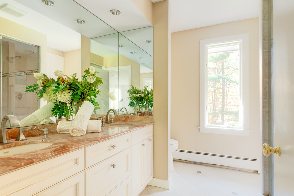Design ideas for a large contemporary master bathroom in Boston with raised-panel cabinets, white cabinets, ceramic floors, a drop-in sink, marble benchtops and beige benchtops.